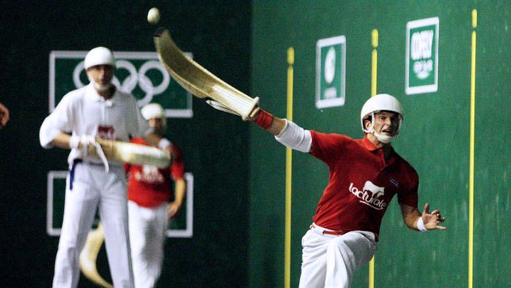 Jai Alai Players on a fronton throwing a ball with the basket glove.